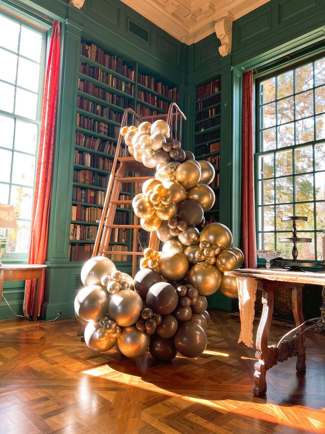 a room filled with lots of balloons and a ladder