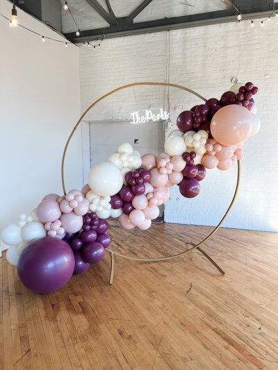 a bunch of balloons are sitting on a wooden floor in a room