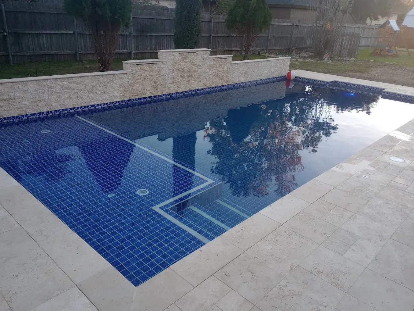 A large swimming pool with blue tiles and a white border