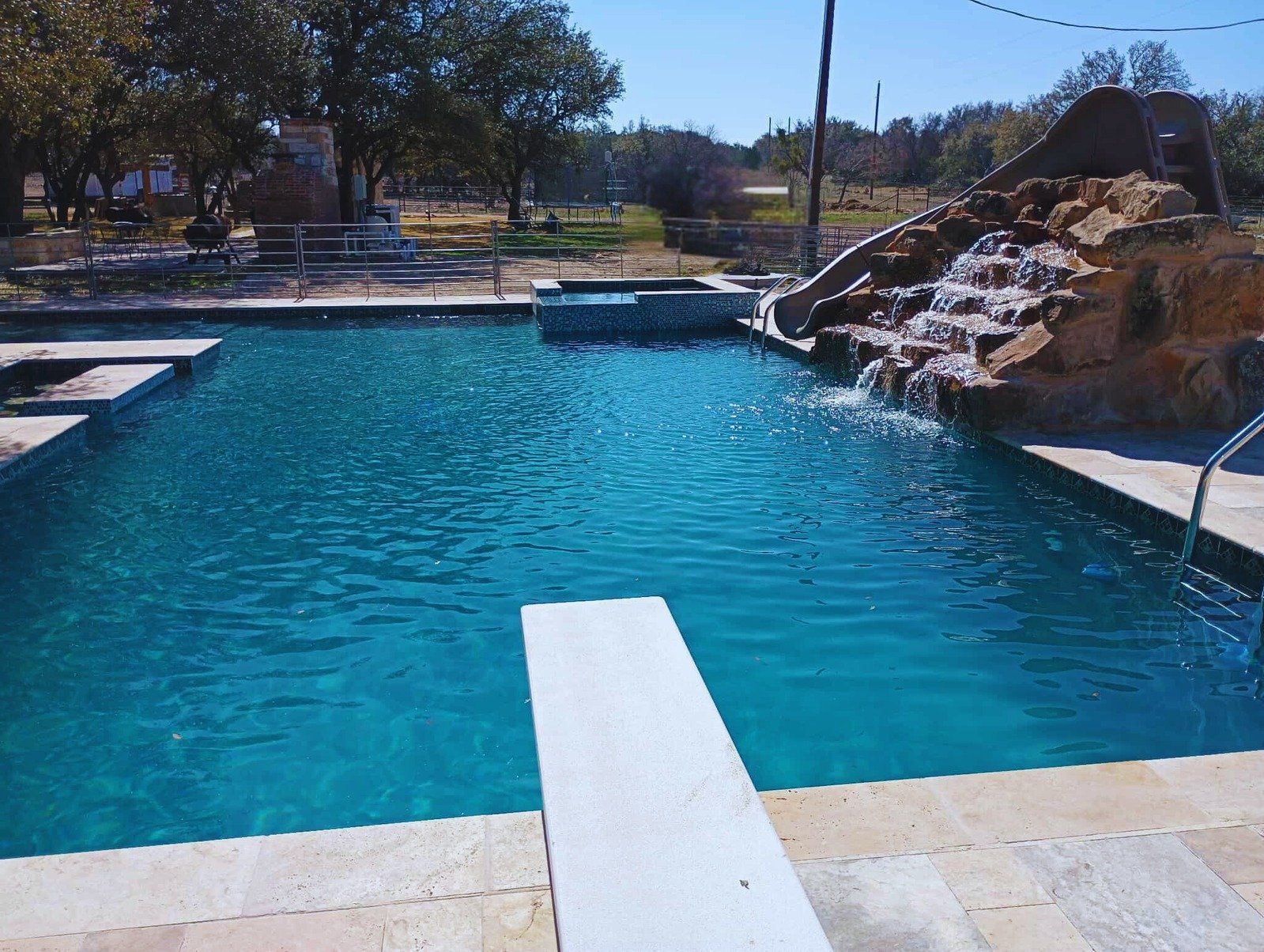 A large swimming pool with a diving board in the middle