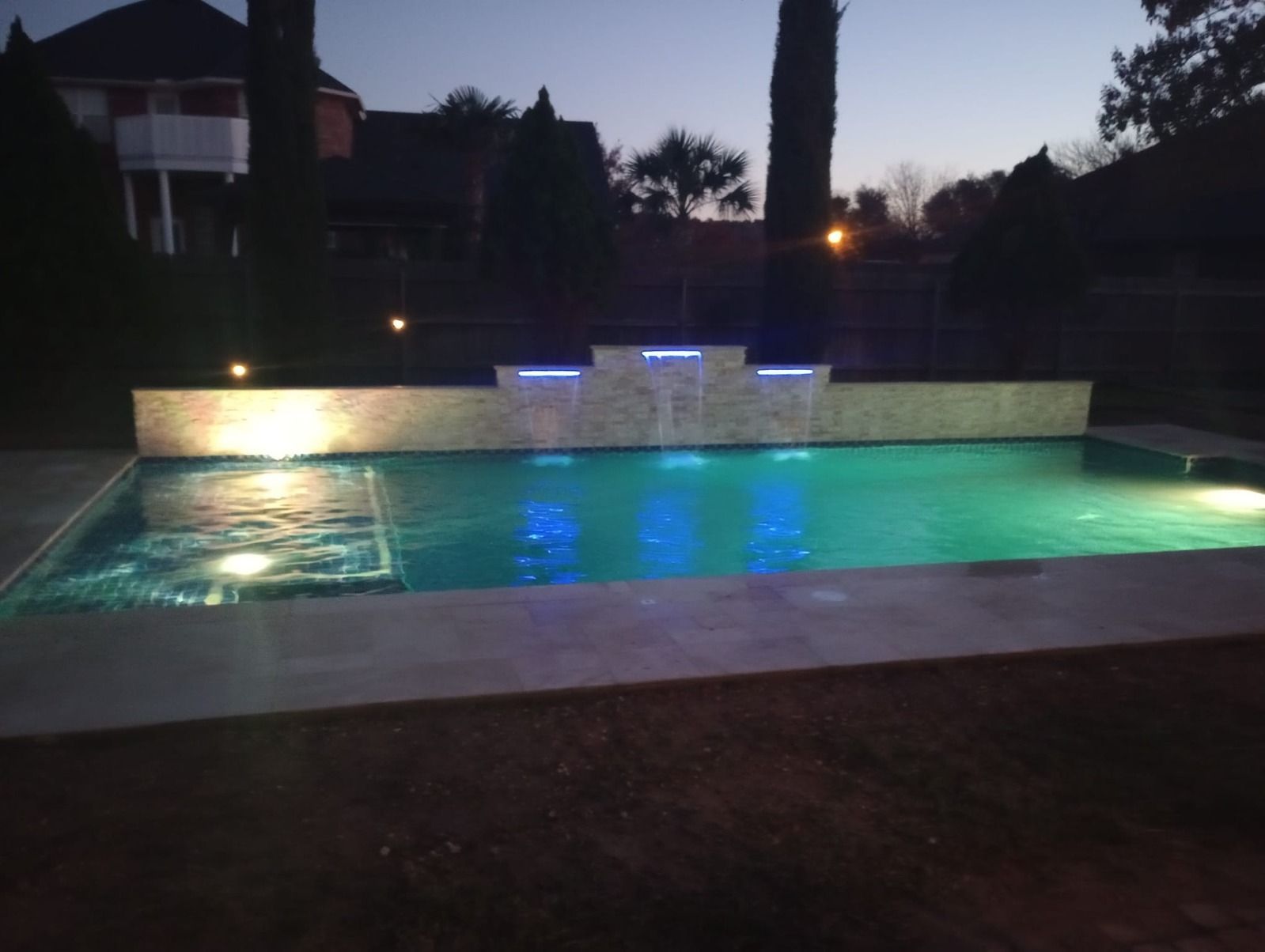A large swimming pool is lit up at night