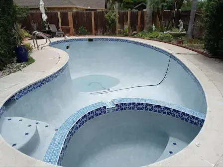 A large swimming pool with a jacuzzi in the middle of it.