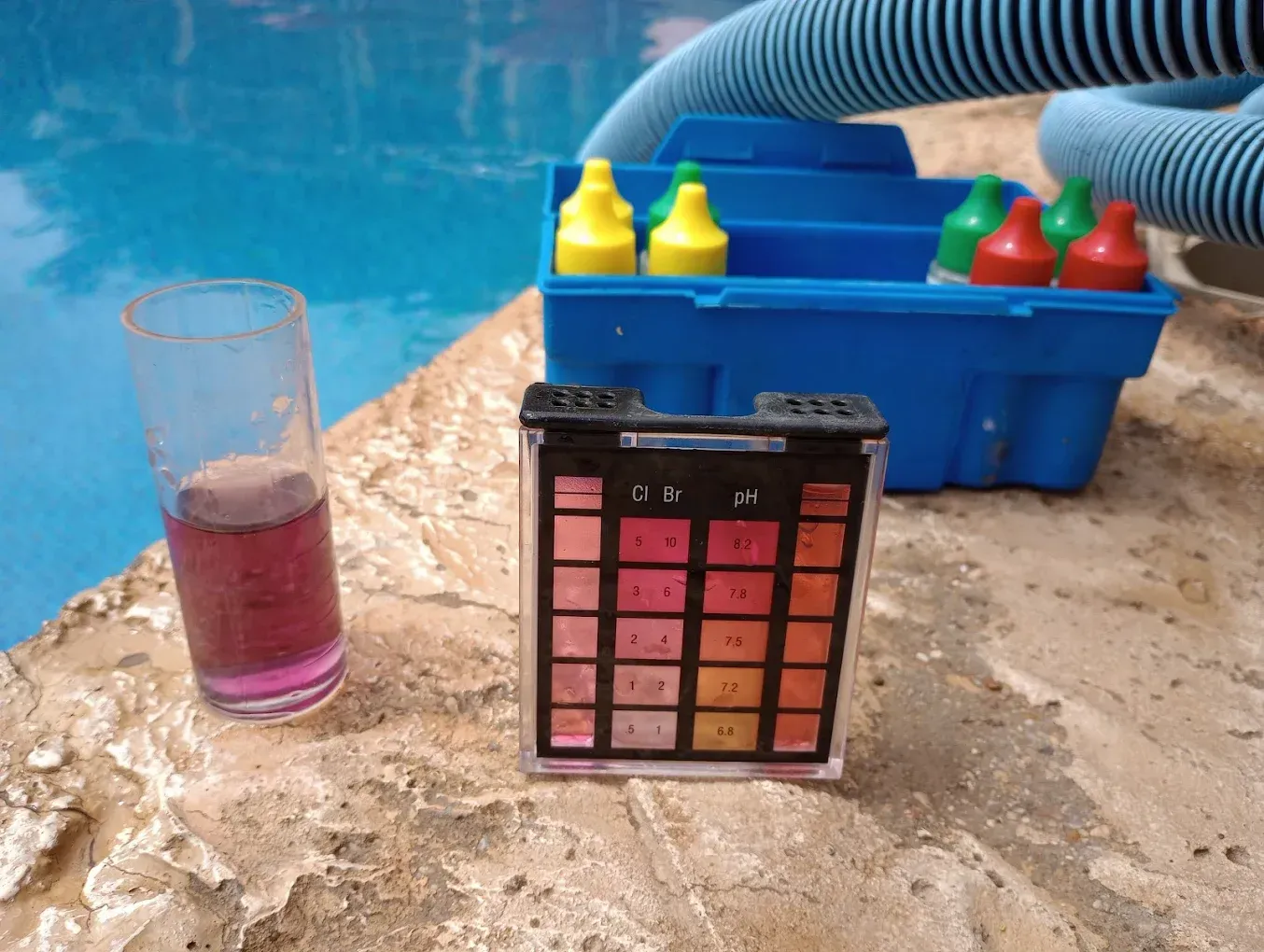 A glass of purple liquid next to a ph meter