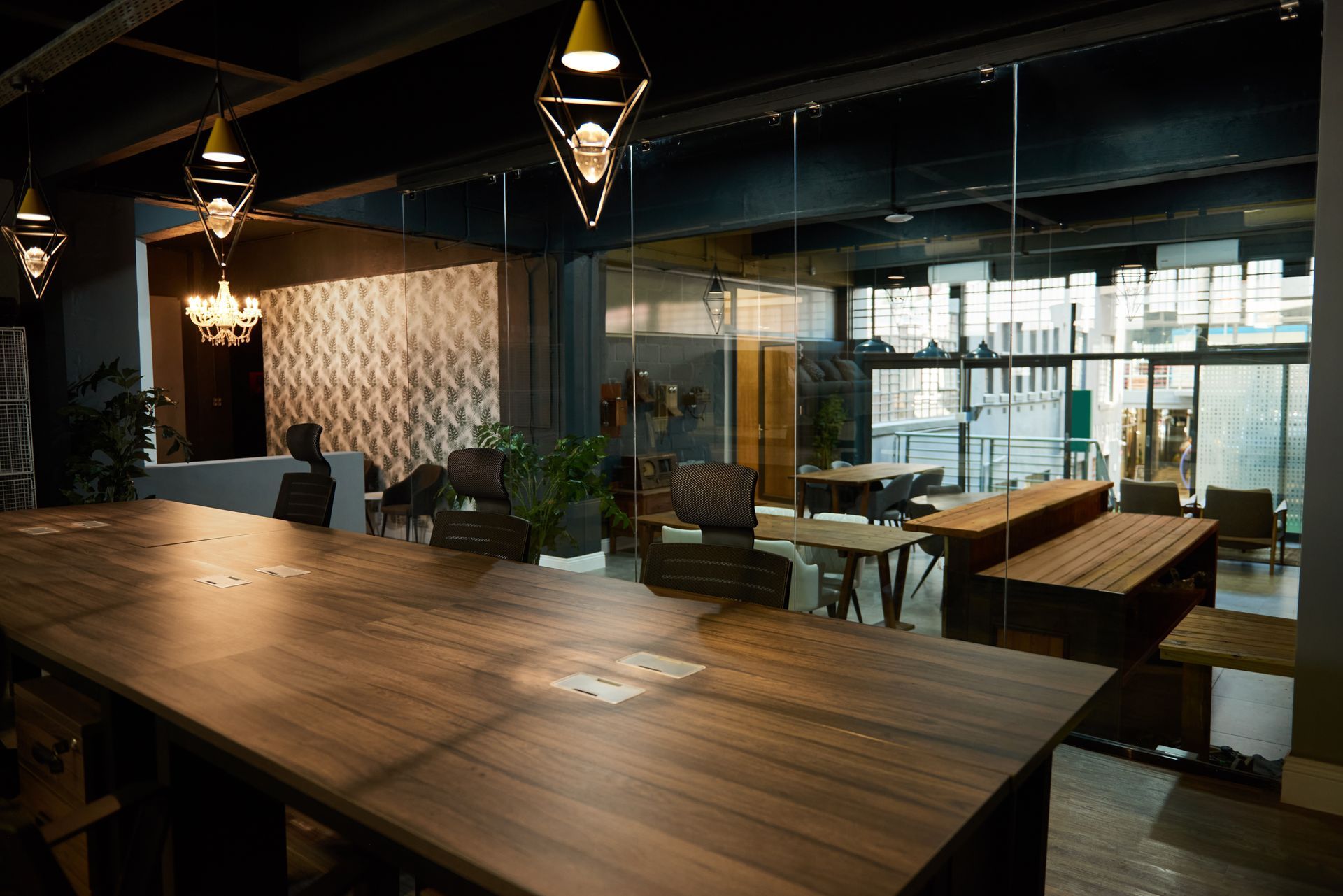 The interior of a modern boardroom with a wooden conference desk and glass walls after hours.