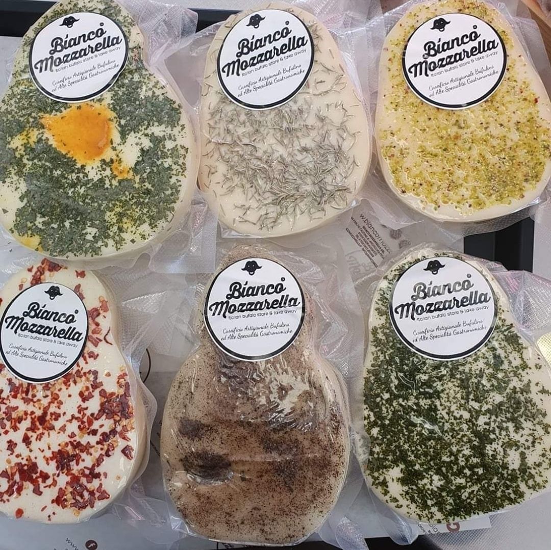 Sei mozzarelle confezionate singolarmente, ciascuna ricoperta con erbe e spezie diverse.