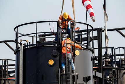 A couple of men are working on a large structure.