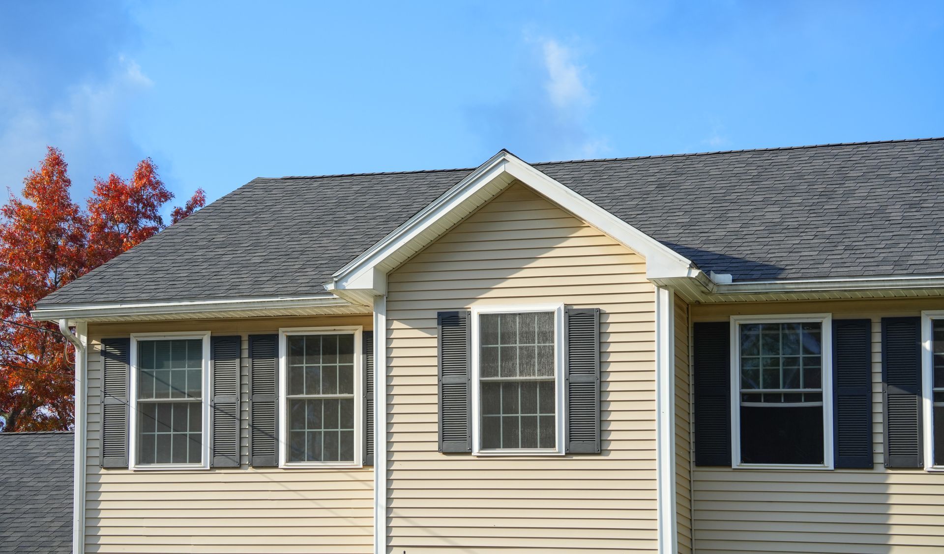 A house with a gray roof and black shutters