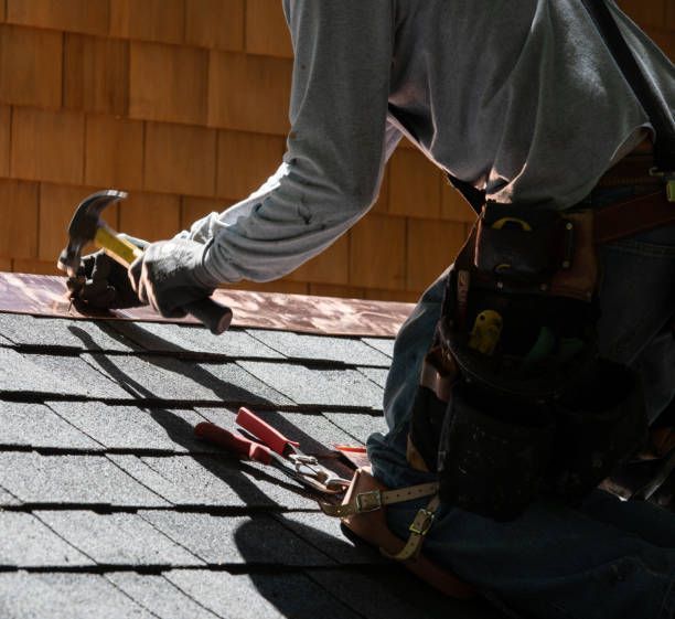 A man is working on a roof with a hammer and pliers