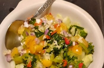 A bowl of salad with a spoon in it