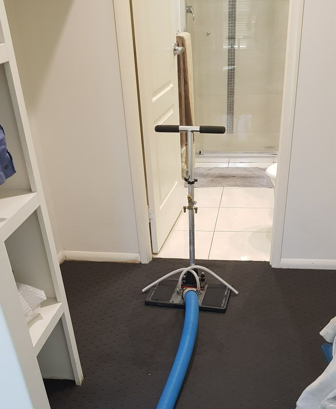 A Vacuum Cleaner is Sitting on the Floor in a Bathroom — Dynamic Services in Blackwater, QLD