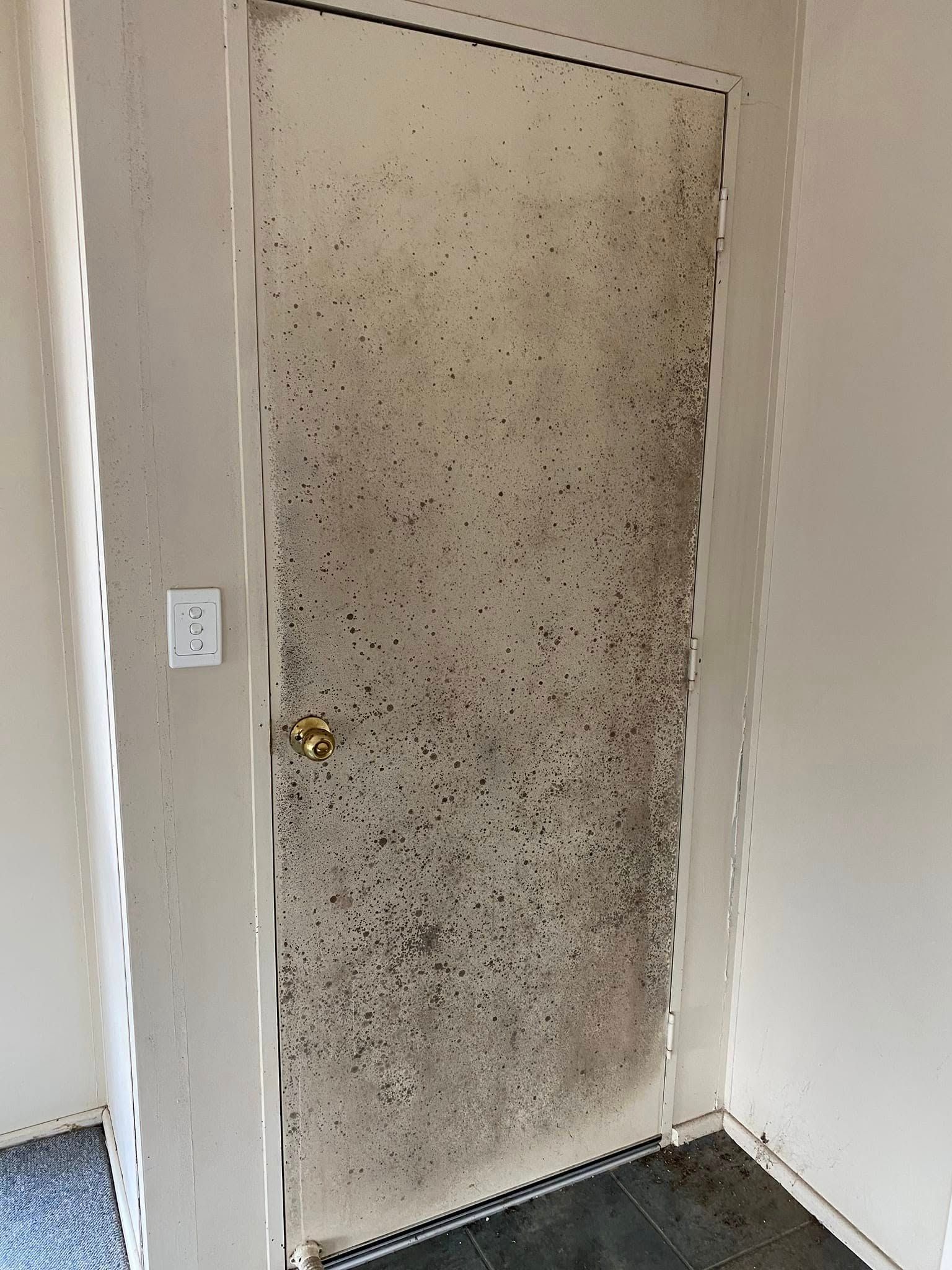 A Person is Cleaning a Wall With a Spray Bottle — Dynamic Services in Limestone Creek, QLD