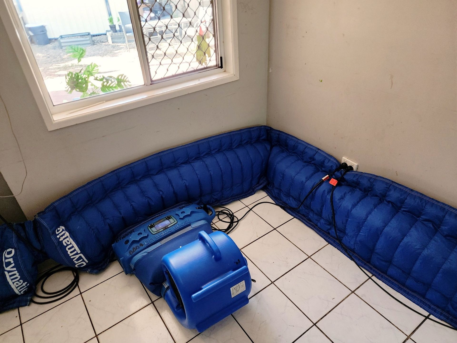 A Red Vacuum Cleaner is Sitting Next to a Yellow Hose in a Room — Dynamic Services in Limestone Creek, QLD