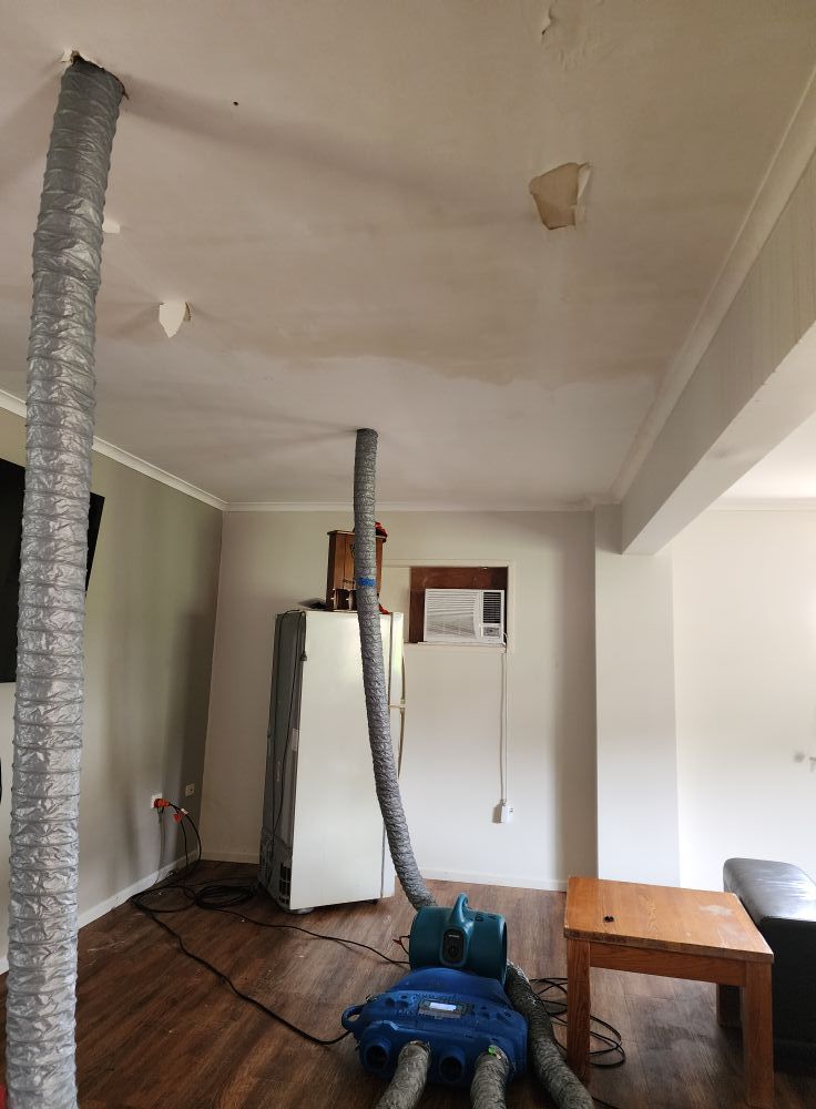 A Vacuum Cleaner is Sitting on the Floor Next to a Yellow Hose — Dynamic Services in Emerald, QLD