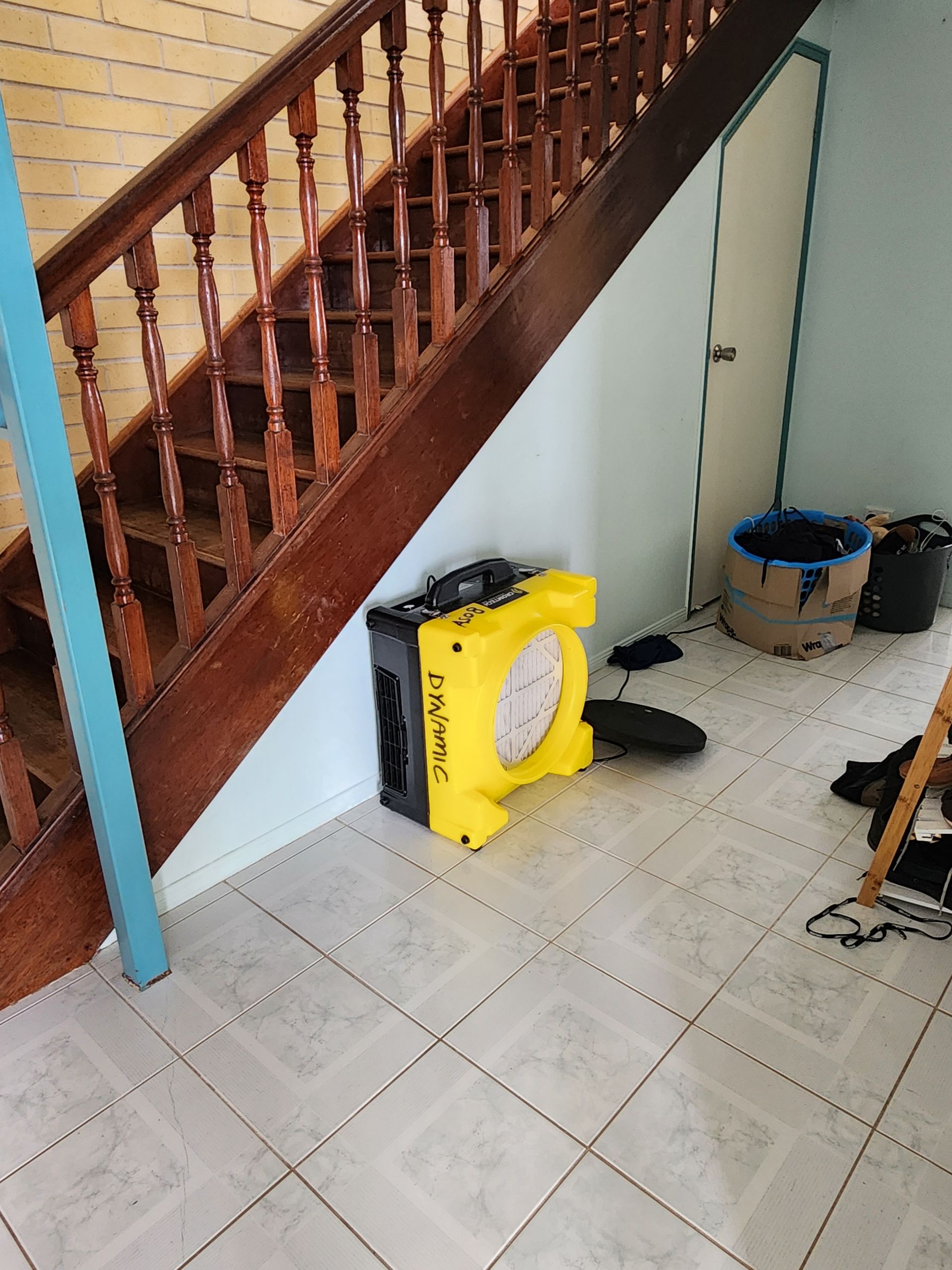 Yellow fan near a staircase. Staircase has wood railing. Blue and white walls.— Dynamic Services in Limestone Creek, QLD