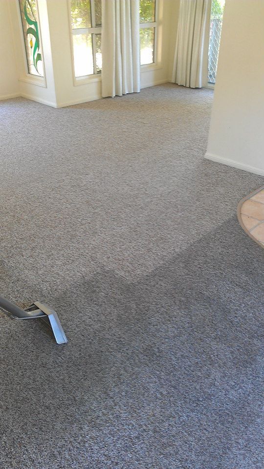 Carpet being cleaned with a machine, showing a clear difference in color.— Dynamic Services in Limestone Creek, QLD