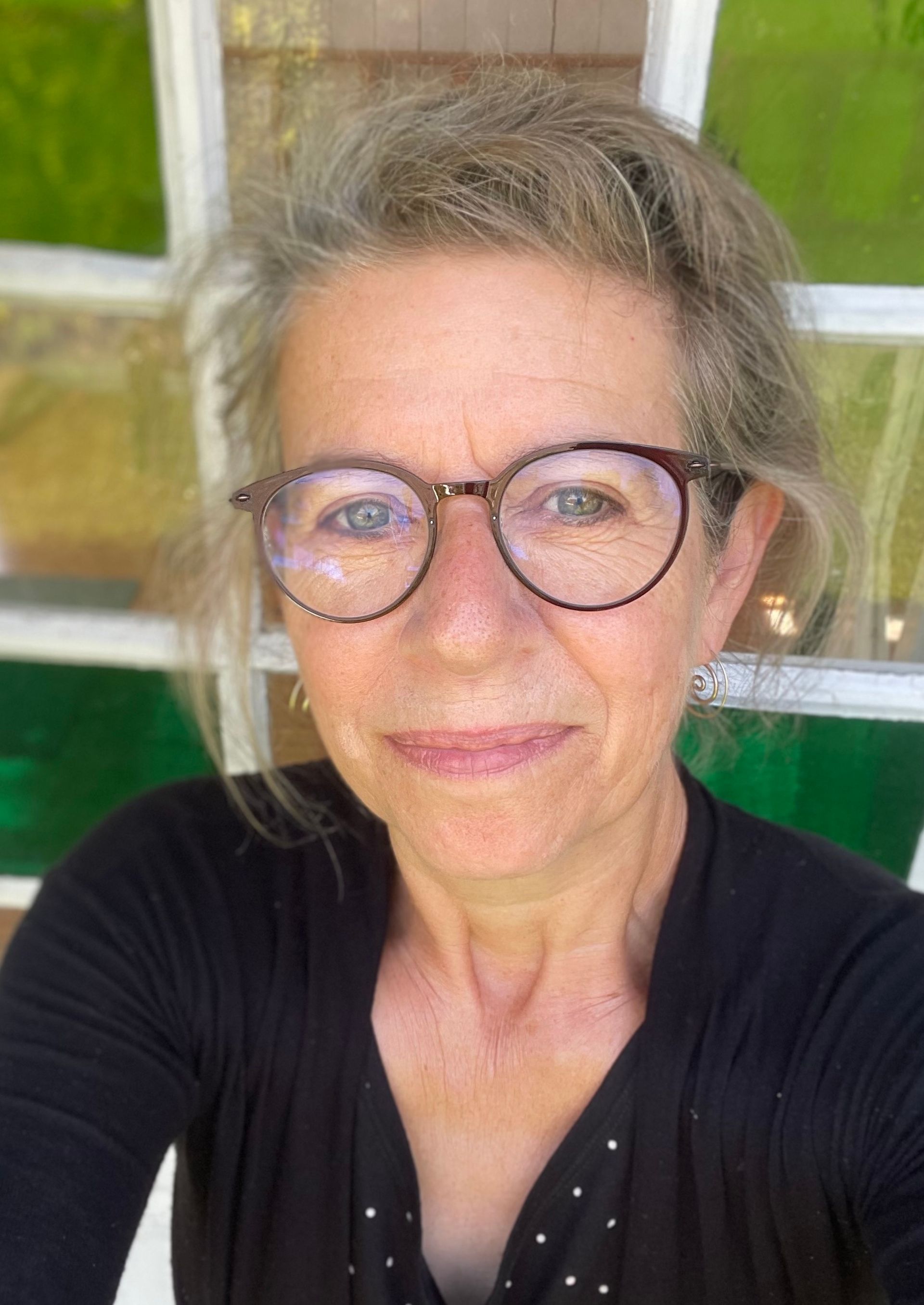 Sussie foran grønne planter i Yogarummet.