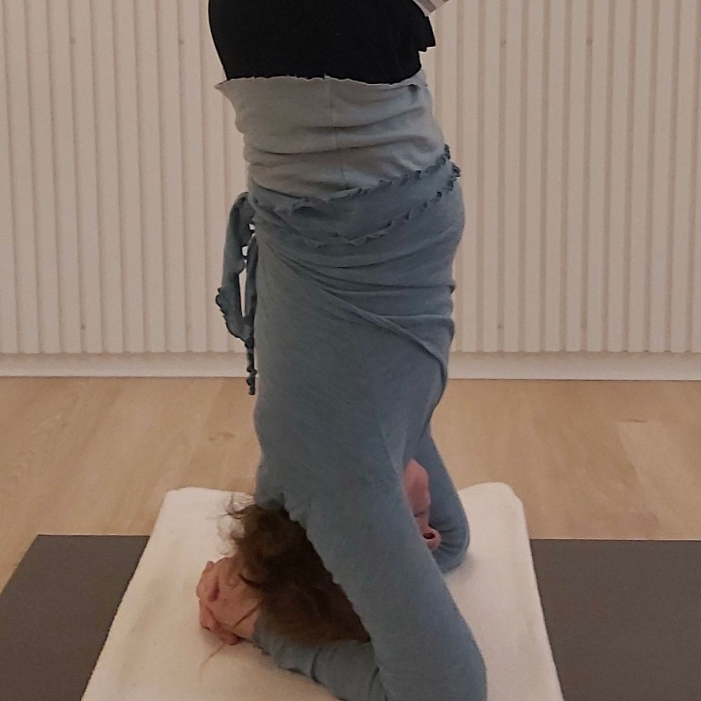 En kvinde laver en yogastilling på en måtte