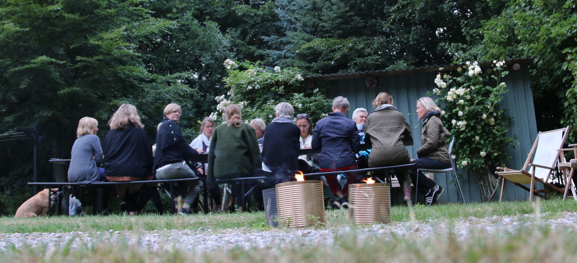 En gruppe mennesker sidder omkring et bord på en mark.