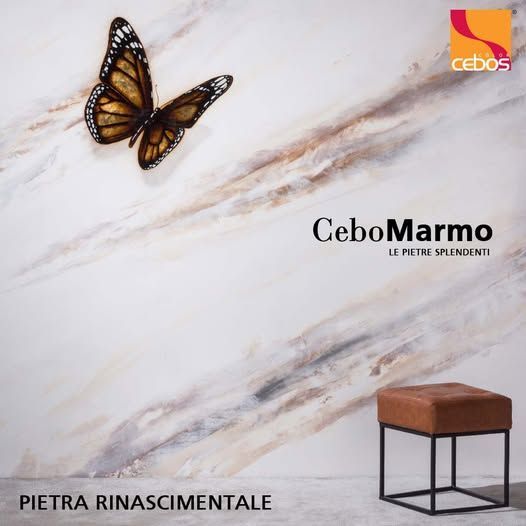 Farfalla su una parete con finitura effetto marmo e sgabello marrone di fronte. Presente il logo Cebos.