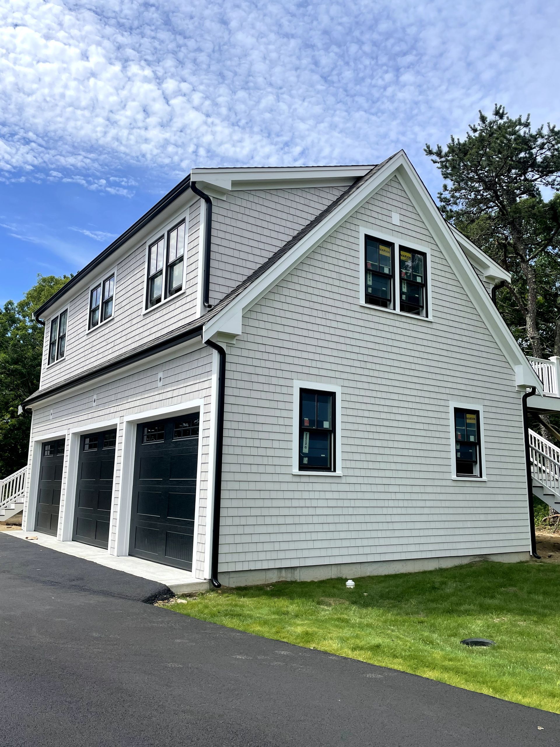 A blue and white house with a car parked in front of it.