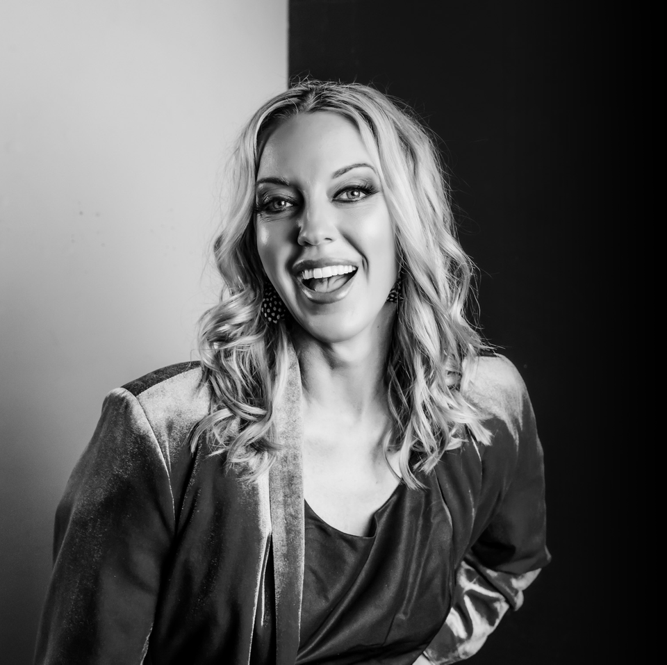 Jaime Strickland CRNA, Owner of About Face Aesthetics & Wellness is smiling in a black and white photo.