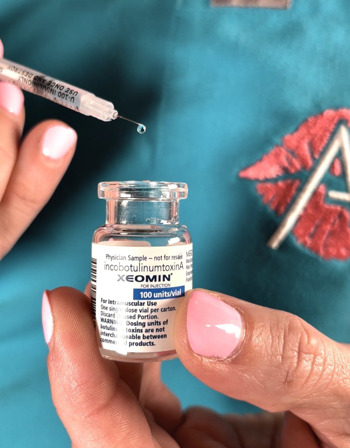 A person is holding a bottle of acomin in their hand