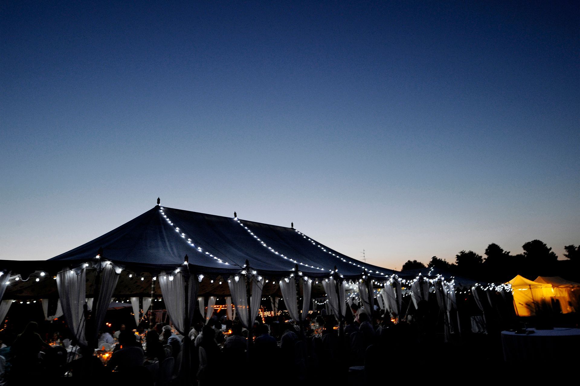 A large tent with lights on it is lit up at night