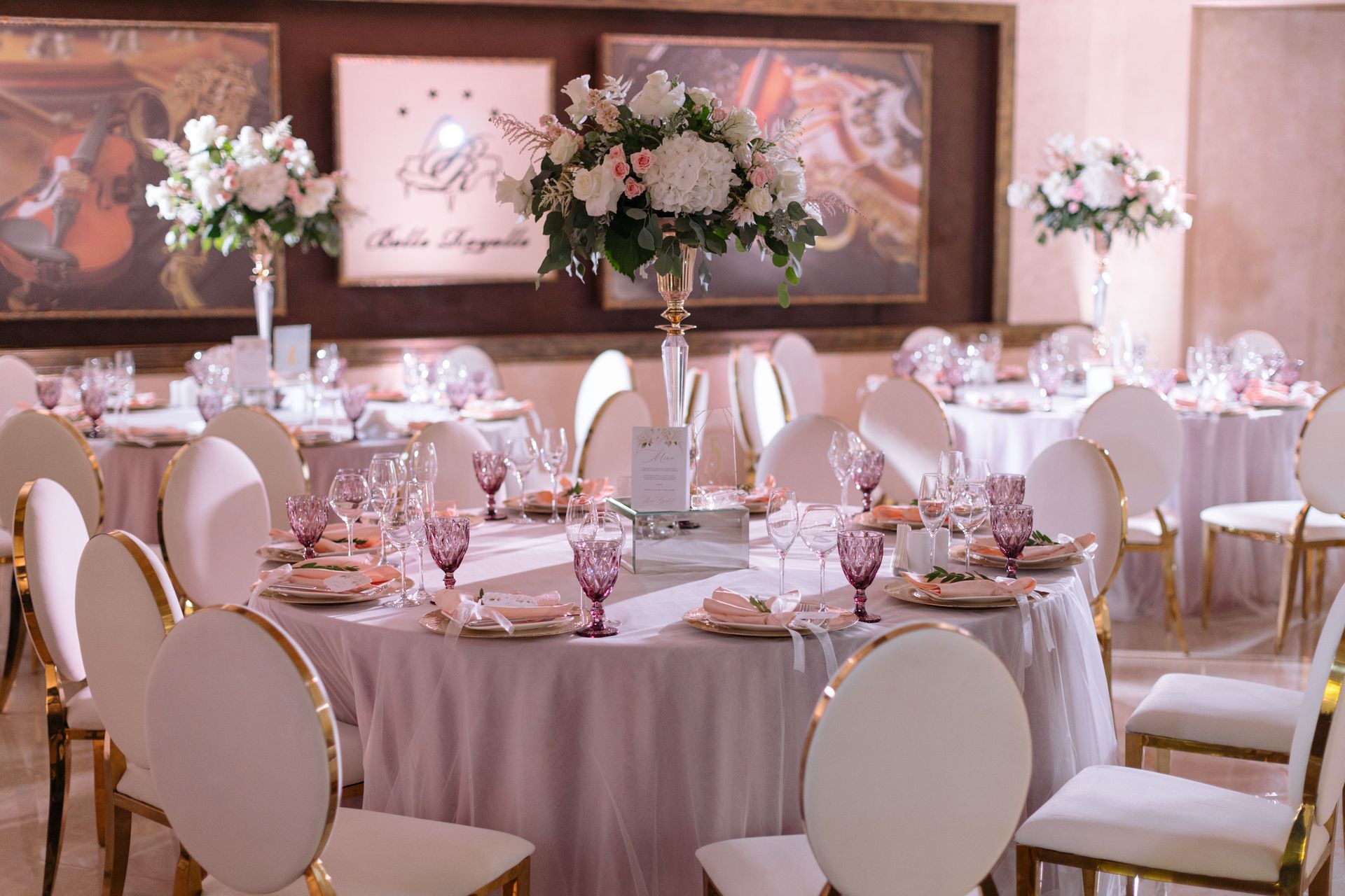 A large room with tables and chairs set up for a wedding reception.