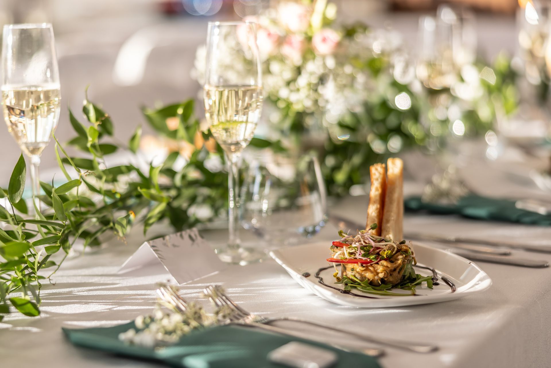 A plate of food is sitting on a table next to a glass of wine.