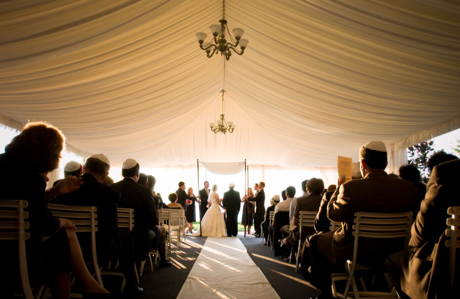 A bride and groom are getting married under a tent