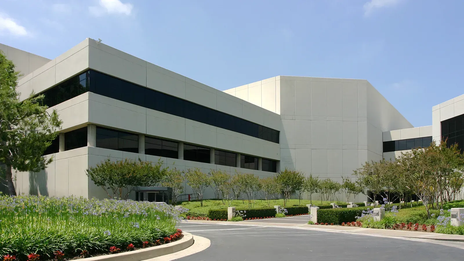Modern building with wood and glass facade, blue sky.