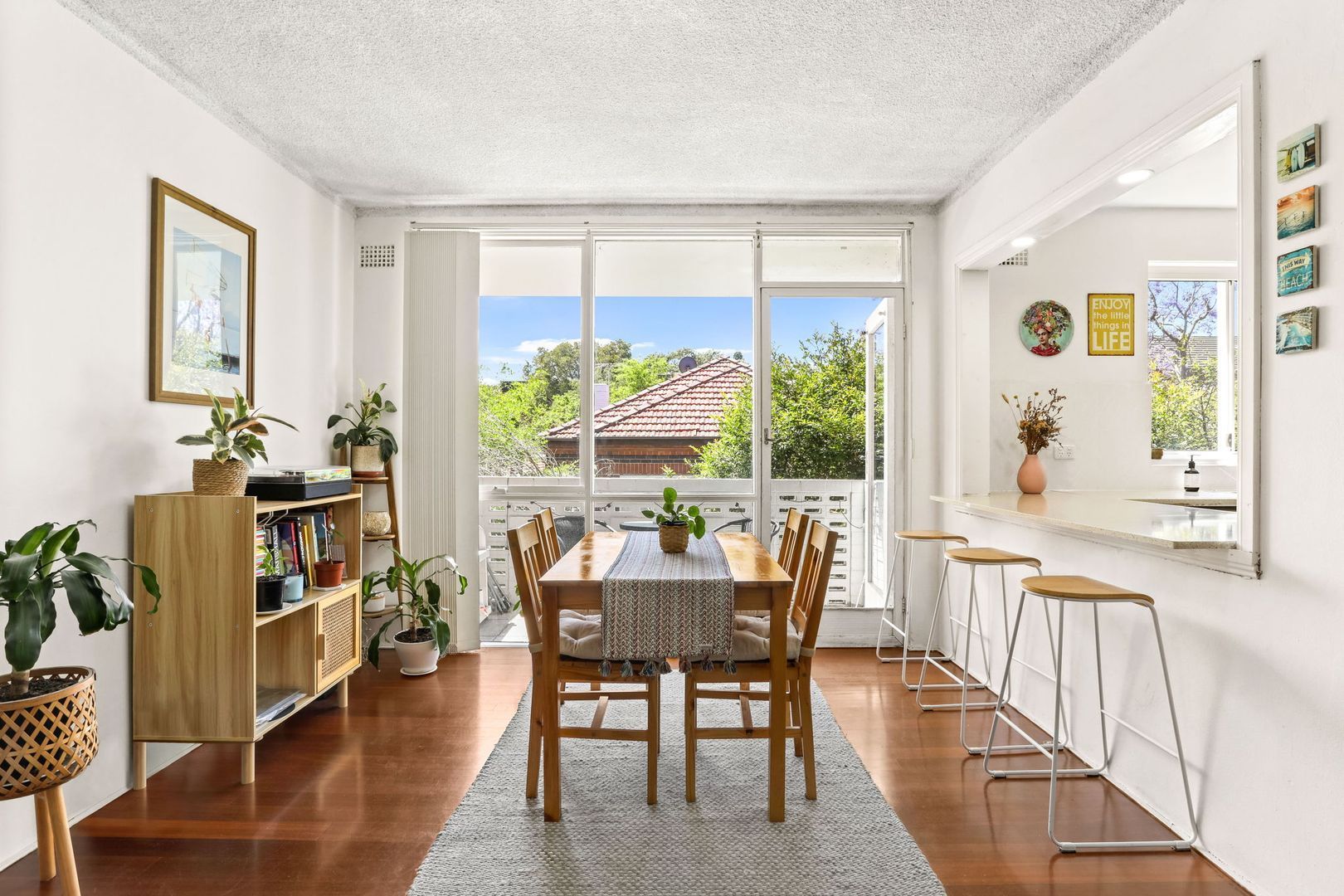 A dining room with a table and chairs and a large window.