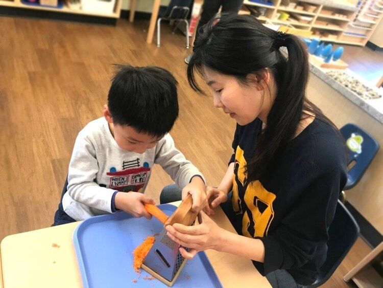 Montessori guide assisting a student