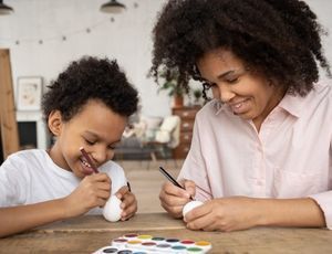Montessori parent and child painting together, sharing connection, and quality time through play