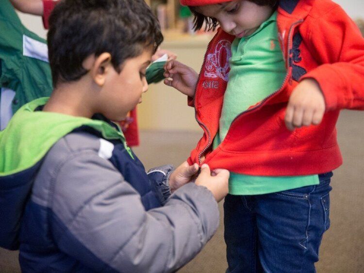 Montessori child- assisting a peer
