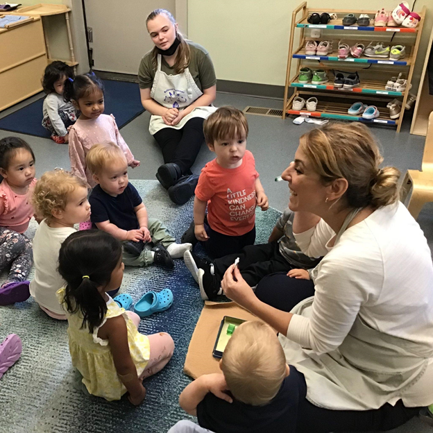 Montessori guide teaching children how to brush their teeth