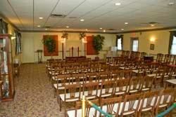 A large room filled with rows of wooden chairs.
