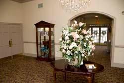 A vase of flowers is sitting on a table in a hallway.
