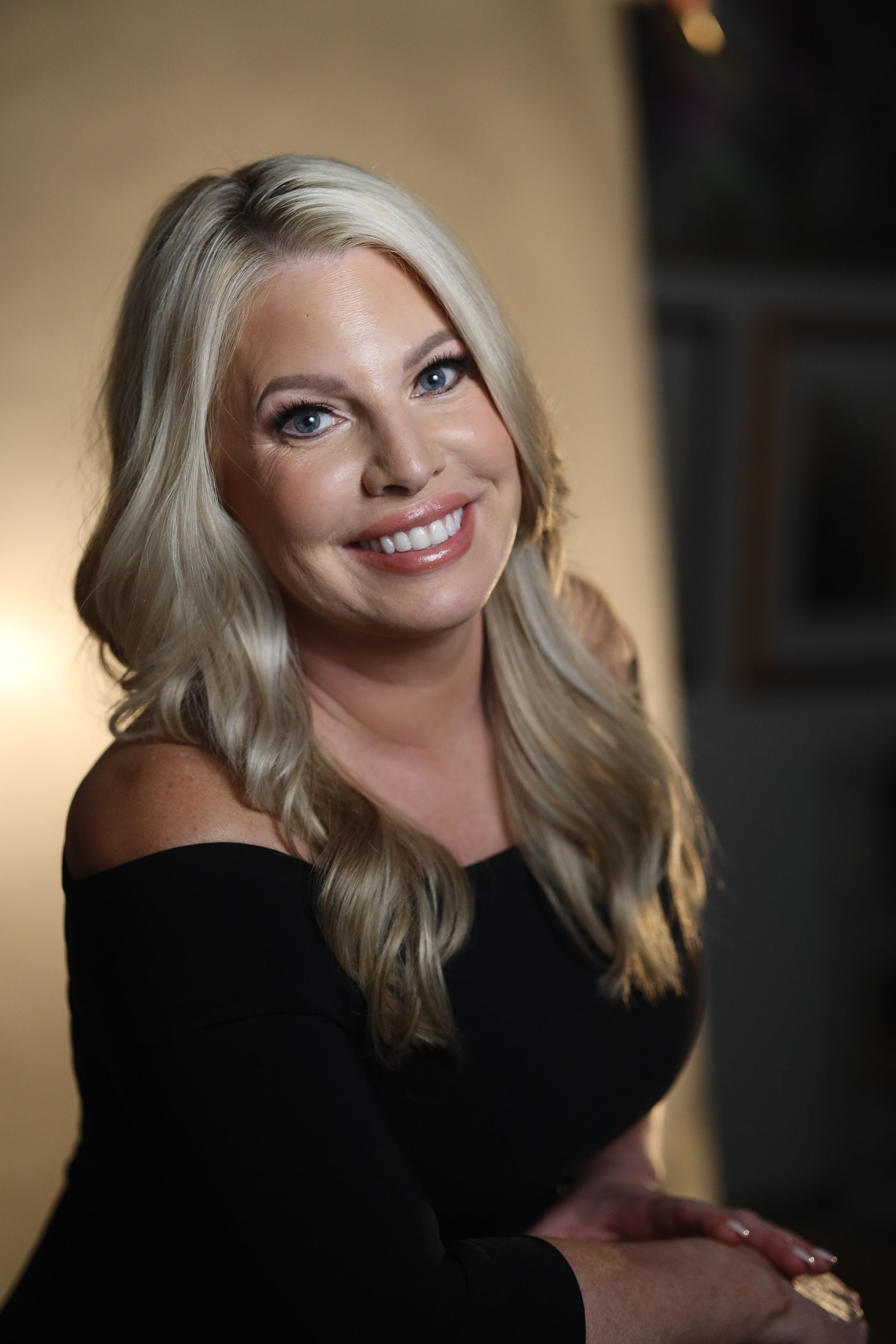 A woman stands behind a table that says skingevity med spa