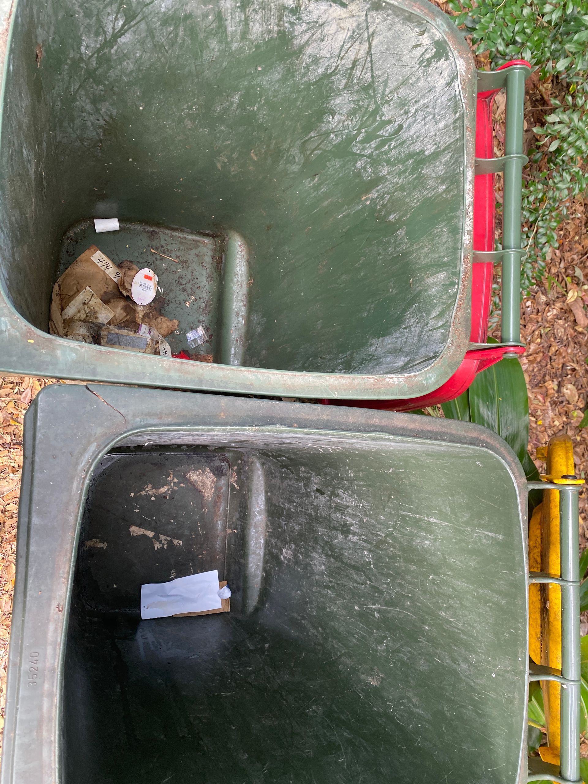 A Person Is Cleaning A Trash Can With A High Pressure Washer — Zac's Bin and Pressure Cleaning In Parramatta Park, QLD