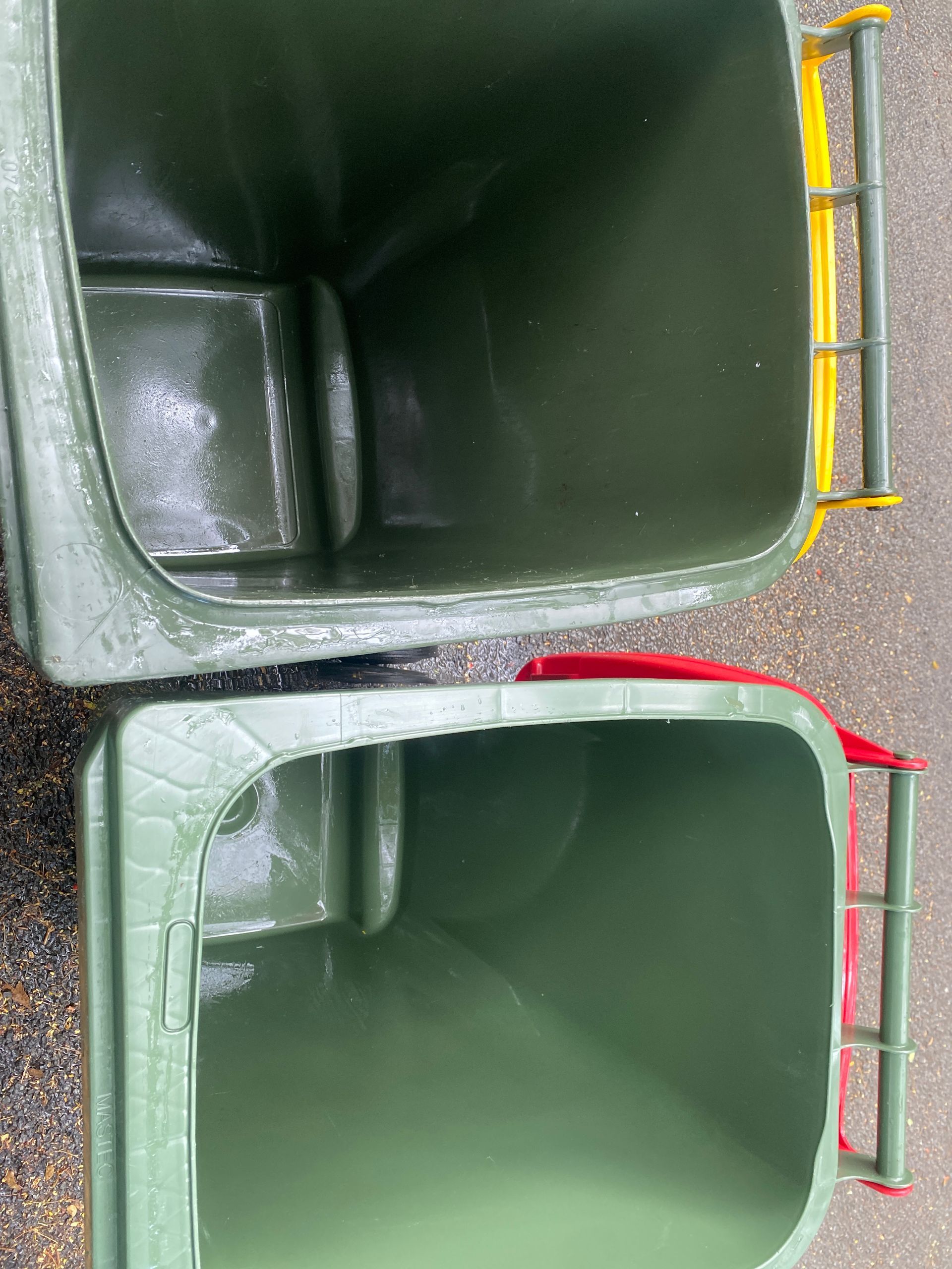 A Person Is Cleaning A Green Trash Can With A High Pressure Washer — Zac's Bin and Pressure Cleaning In Parramatta Park, QLD