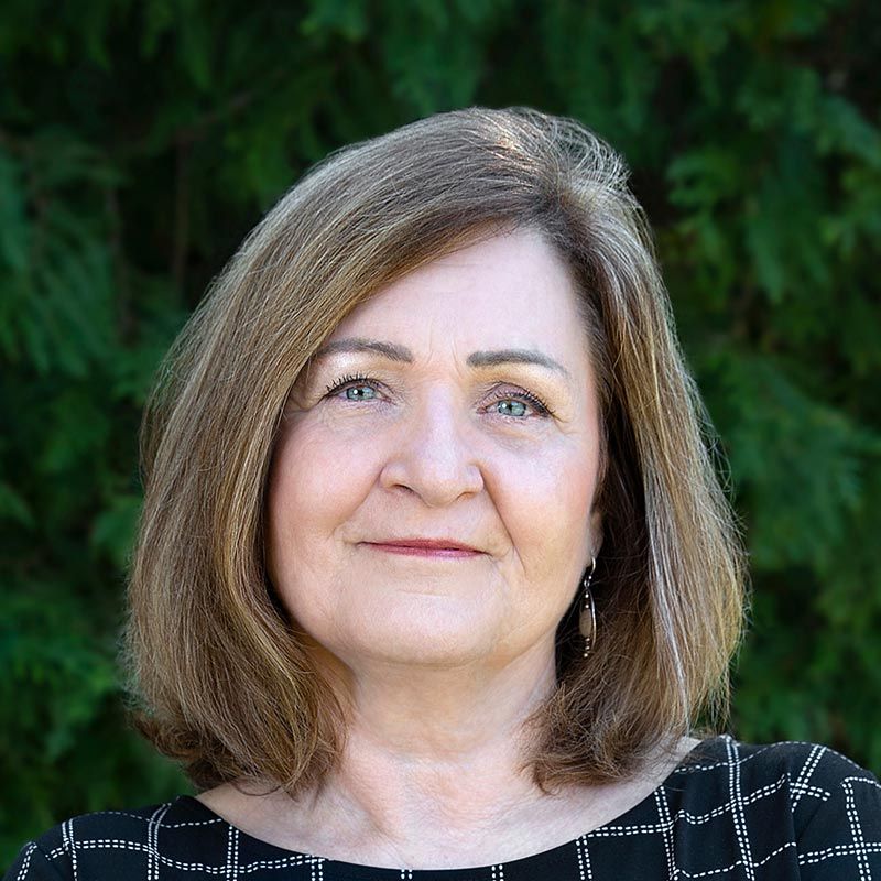 a close up of a woman 's face with trees in the background .