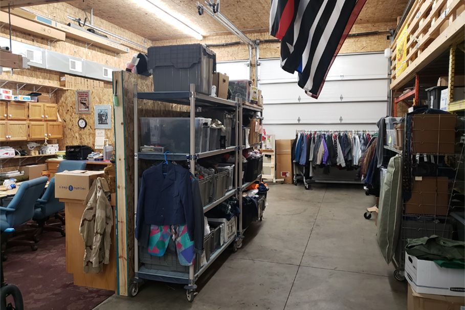 A large room with a lot of shelves and clothes hanging on them.