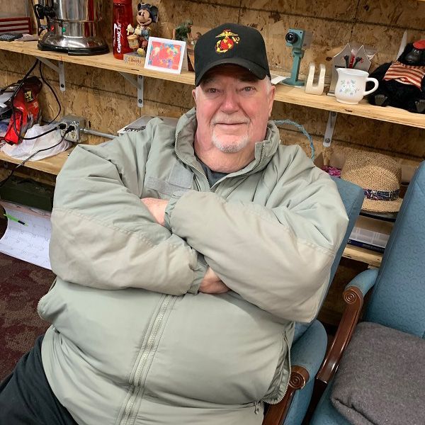 A man is sitting in a chair with his arms crossed