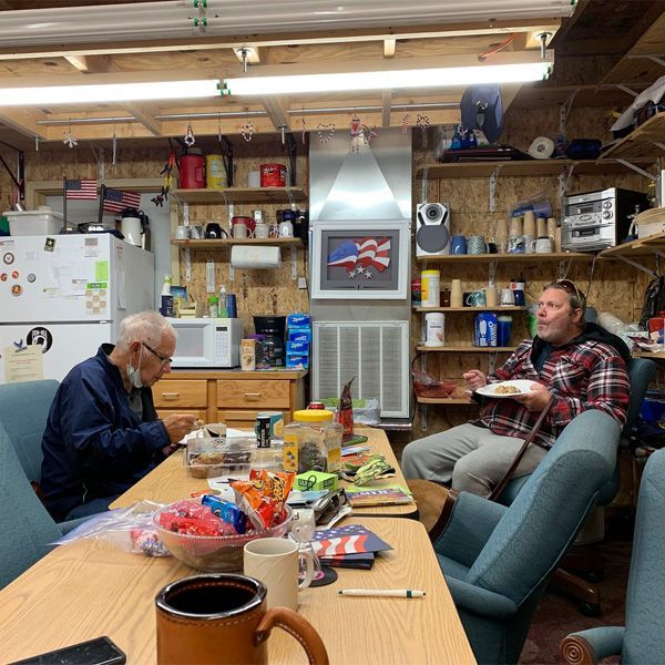 A group of men are sitting around a table eating food