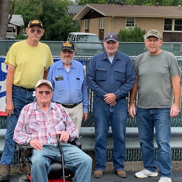 A man in a wheelchair is surrounded by other men
