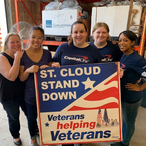 A group of women holding a sign that says veterans helping veterans