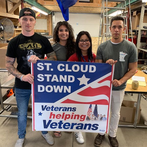 A group of people holding a sign that says
