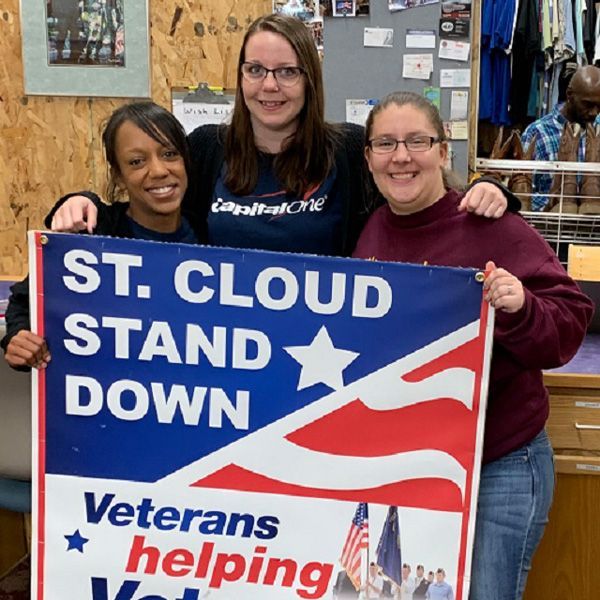 Three women holding a sign that says