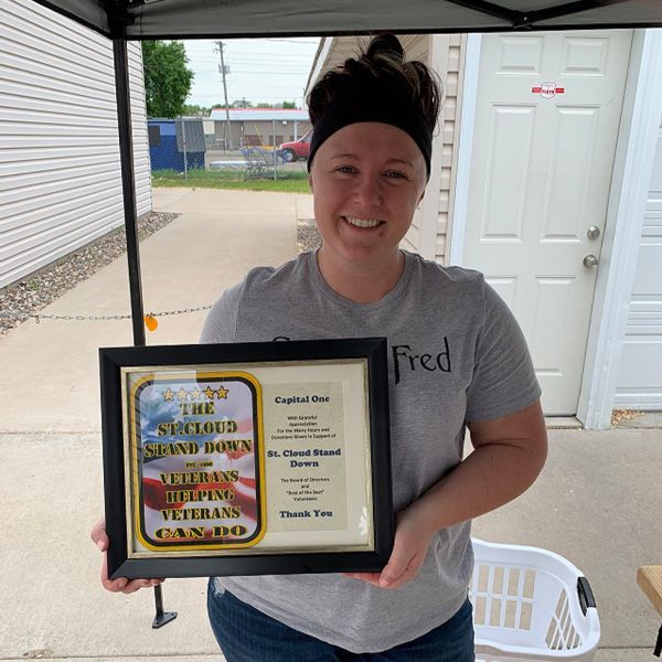 A woman holding a framed certificate that says fred